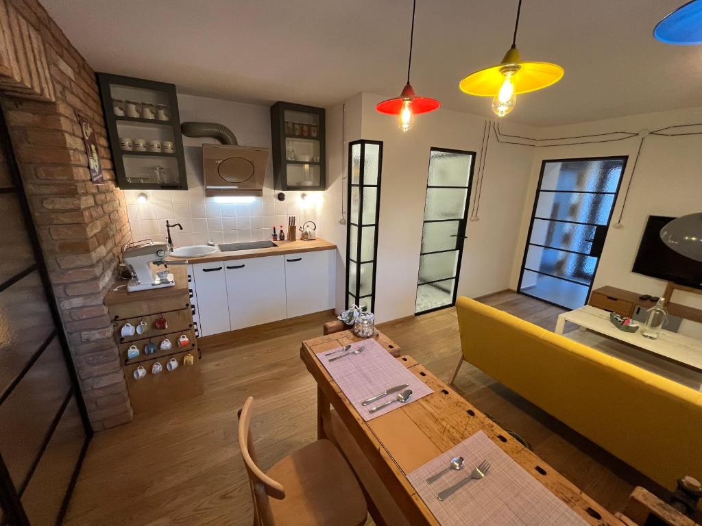 布尔诺Bydlit cz的厨房以及带桌子和沙发的用餐室。