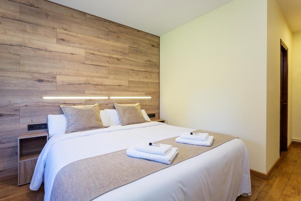 拉波夫拉-德利列特Hostatgeria Falgars的一间卧室配有一张大床和两条毛巾