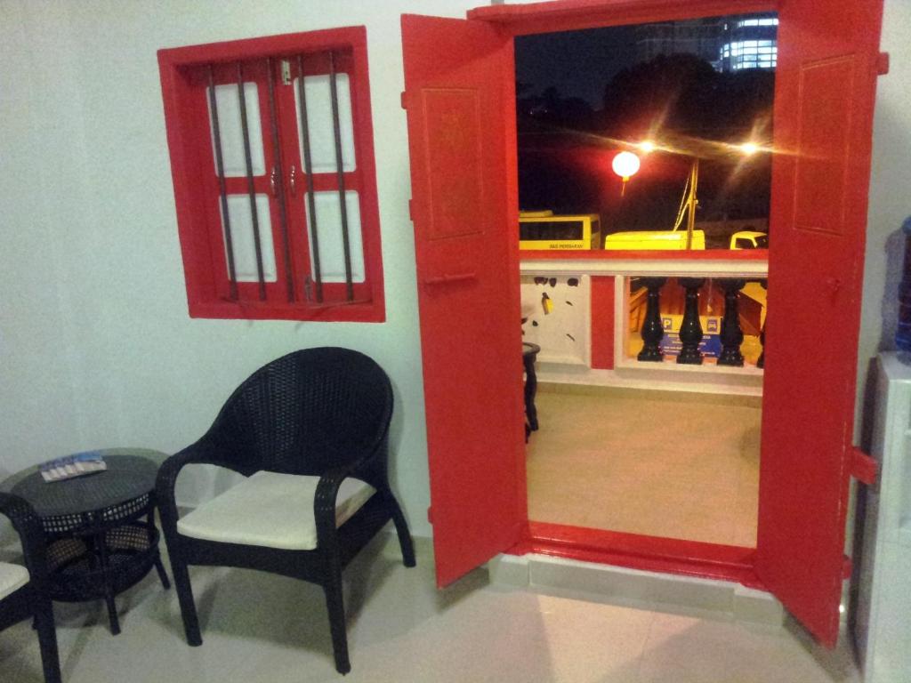 瓜拉丁加奴KT Chinatown Lodge的一间带两把椅子的房间和一间带镜子的房间