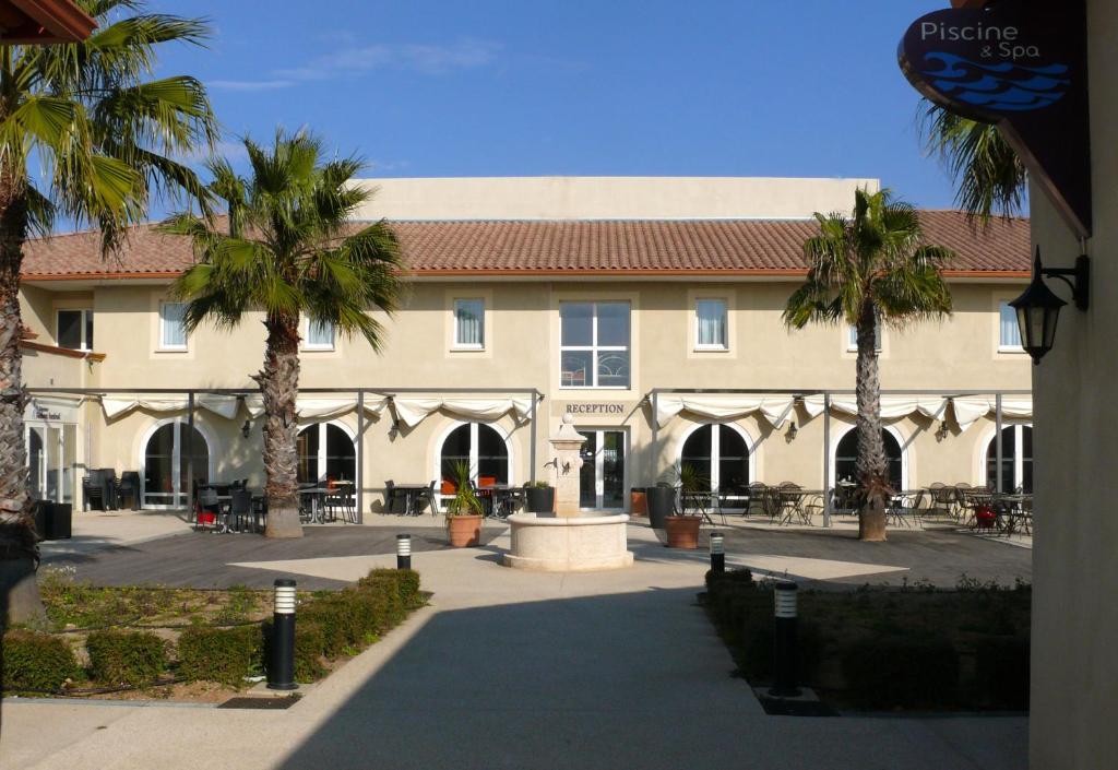 加拉尔盖莱蒙蒂厄雅塞德卡马格酒店的一座棕榈树环绕的大建筑