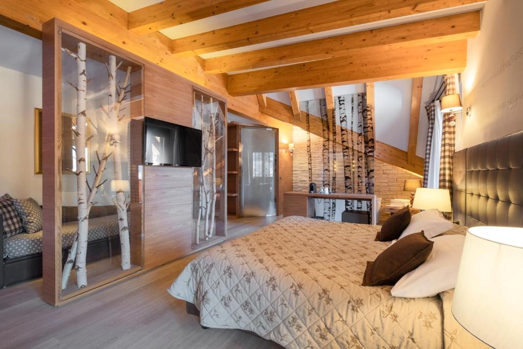 安达洛Il Piccolo Dolomiti Resort的一间卧室设有一张大床和木墙