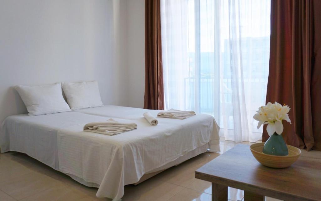 乌尔齐尼Ponte Apartments的卧室配有一张白色的床、桌子和窗户。