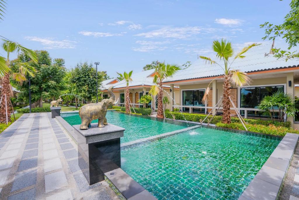 七岩Tontan Resort Cha-am的一座位于房子前面的游泳池,旁边设有熊雕像