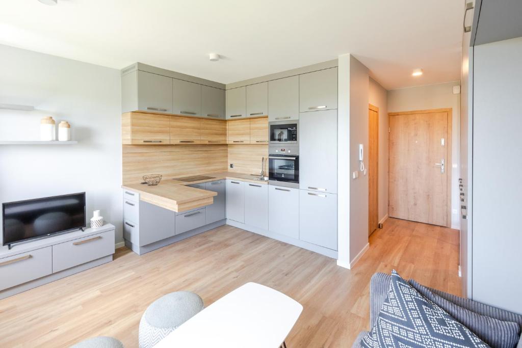奥普尔Apartment Natura Vision的一间厨房,配有白色橱柜和一台电视机