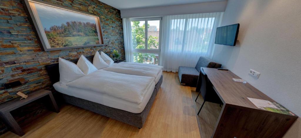 阿尔勒斯海姆艾尔米塔什酒店的一间卧室配有一张床、一张桌子和一个窗户。