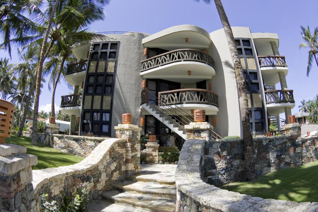 喀巴里特埃尔玛格尼菲科公寓式酒店的棕榈树海滩上的一座建筑