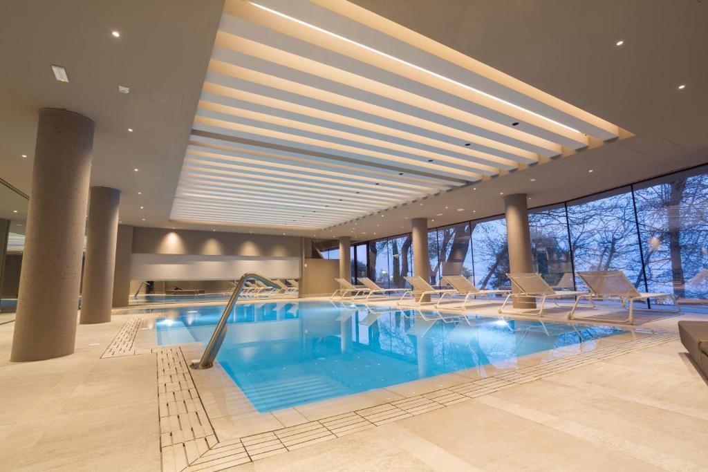 扎费拉纳-埃特内阿阿依诺尼健康酒店的酒店的大型游泳池配有椅子
