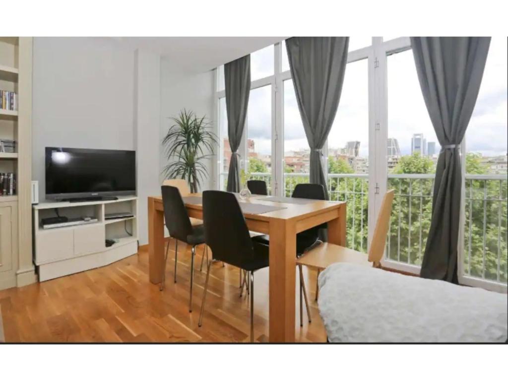 马德里Madrid Views Apartment的客厅设有餐桌和椅子