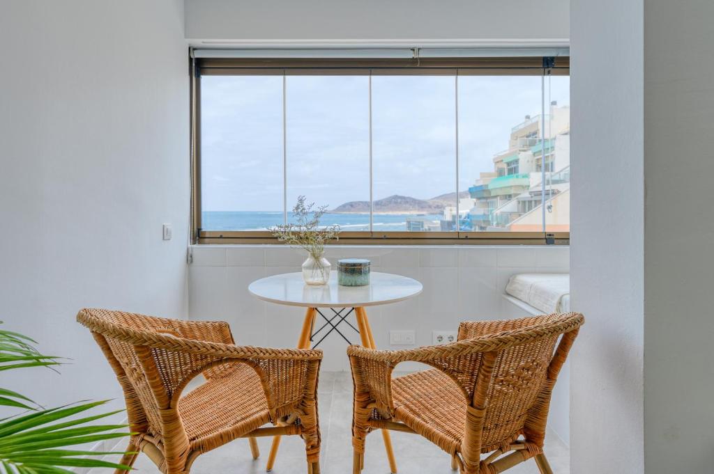 大加那利岛拉斯帕尔马斯Stylish Sea View Accommodation Las Canteras的窗户间里的一张桌子和两把椅子