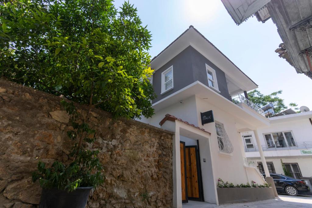安塔利亚Villa Italic的白色的房子,有石墙和一棵树