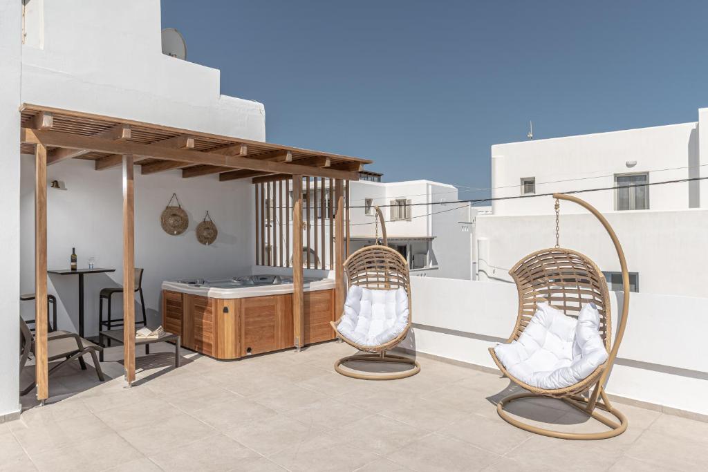 纳克索乔拉Naxos Apartment的阳台的天井配有2把椅子和1张桌子