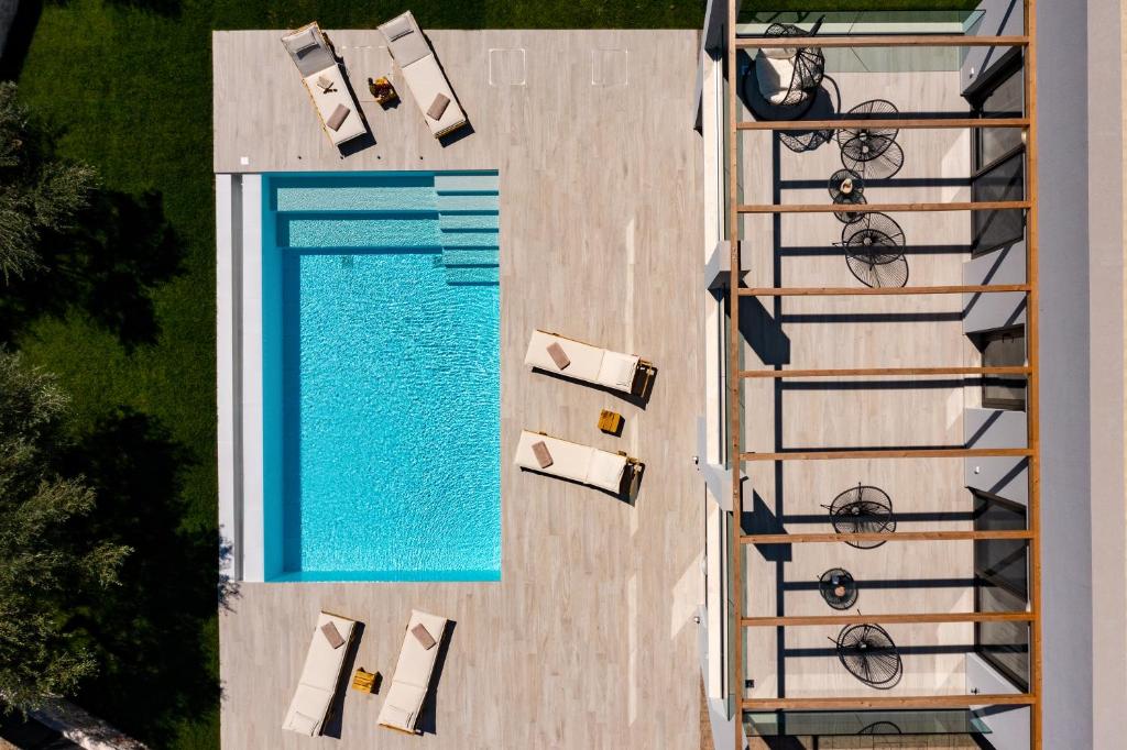 PsarouAriadne Elegant Villa的享有带躺椅和椅子的游泳池的顶部景致