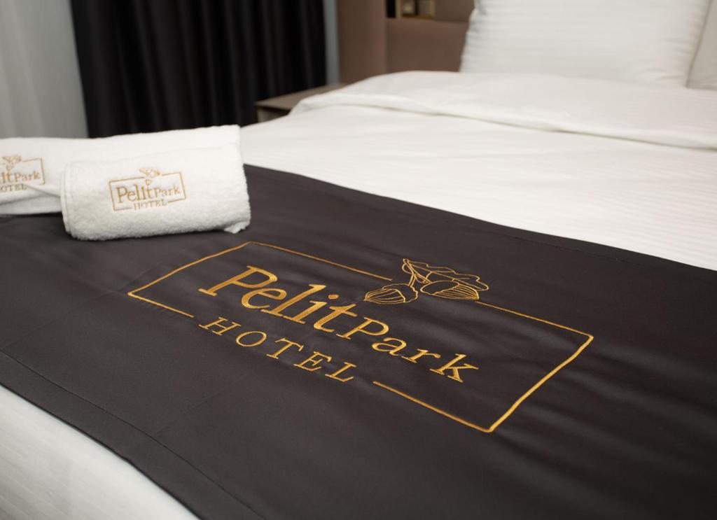特拉布宗Pelit Park Hotel的酒店客房的床上摆放着黑色和金色的毯子