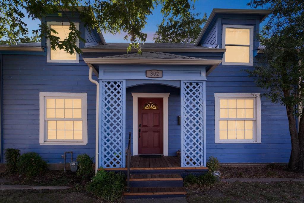 大草原城The Old Downtown Historic Grand Prairie House home的蓝色的房子,有红色的门