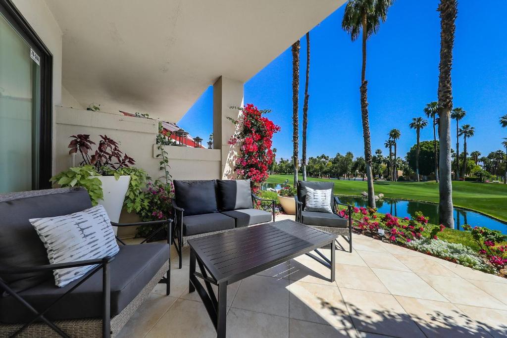 棕榈荒漠Palm Valley Full Access to Golf, Tennis, and Pickle Ball- Luxury 3 King Beds 3 Full Baths的一个带桌椅的庭院和一个游泳池