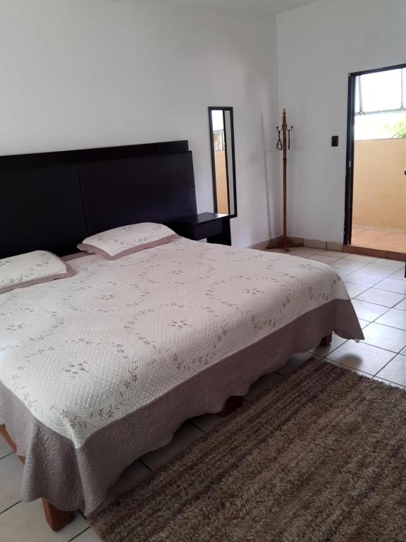 迪坡斯特兰Posada Bugambilias的一间卧室配有一张大床和黑色床头板