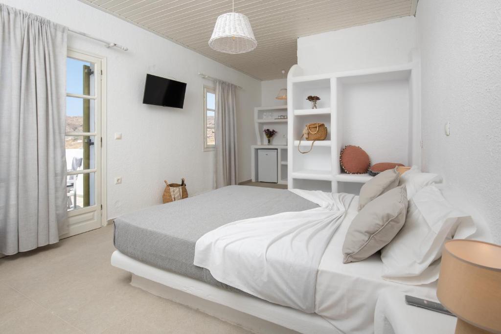 米科利维亚Vavoulas Village的一间白色卧室,配有床和电视
