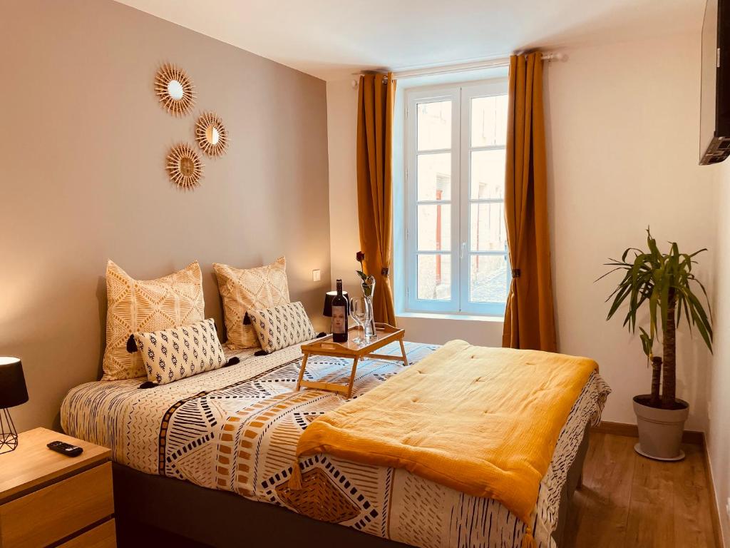 圣艾米隆Maison De La Tour的一间卧室配有一张带桌子和窗户的床
