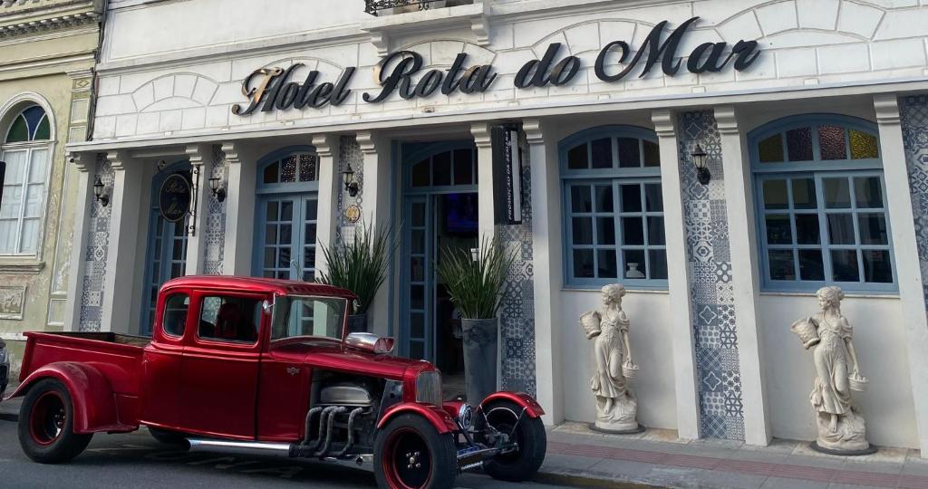 伊达贾伊Hotel Rota Do Mar Inn Itajaí Navegantes的停在大楼前的一辆旧红色卡车