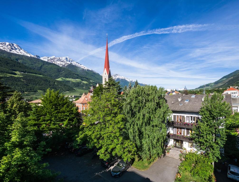 西兰德罗Hotel Pension Schweitzer的一座教堂,教堂的背景是红色的陡峭山峰