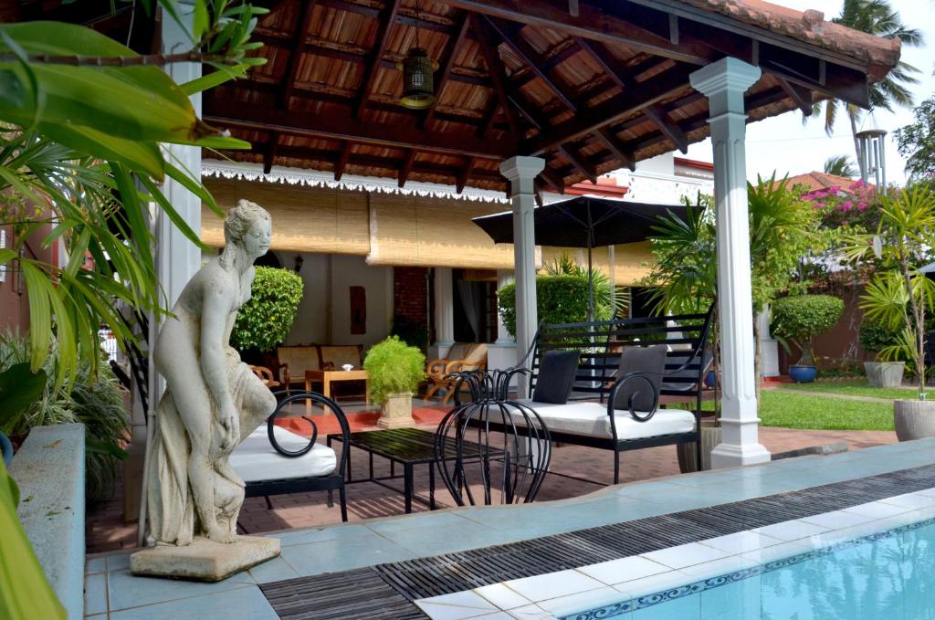 尼甘布阿玉波湾旅馆的站在游泳池旁的女人雕像