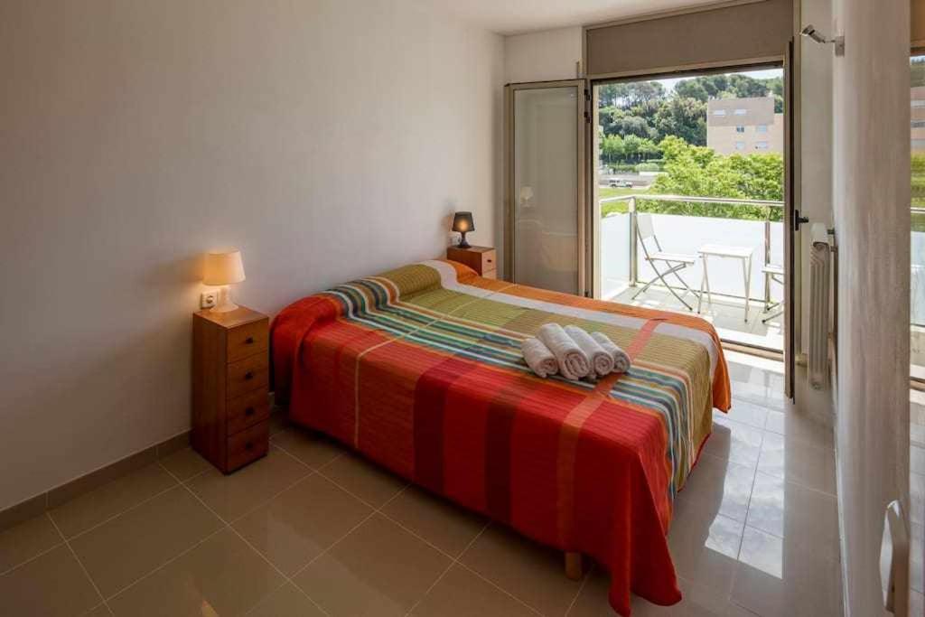 赫罗纳Apartamento Riu Fluvià Girona的一间卧室设有一张床和一个大窗户