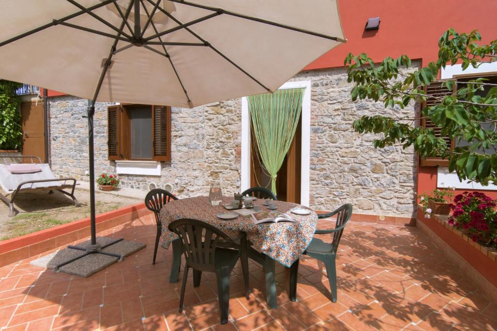 卡萨尔韦利诺Costiera del Cilento Apartments的庭院内桌椅和遮阳伞