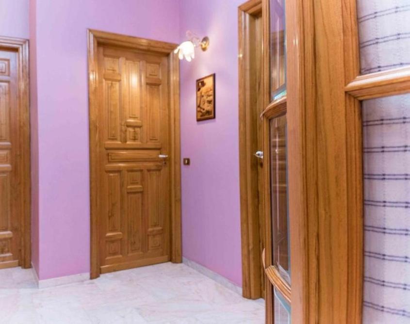 卡斯特布奥诺Casa Mare e Monti Castelbuono的走廊设有两扇木门和紫色墙壁