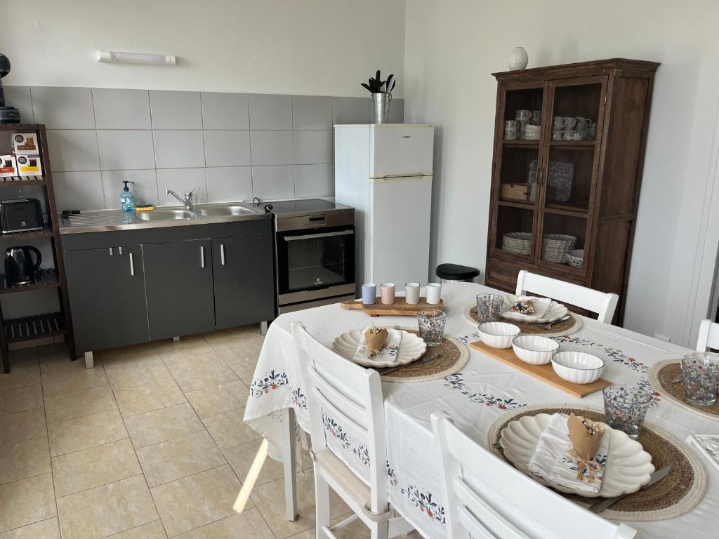 ArleufMaison au coeur du Morvan的厨房配有桌椅和冰箱。