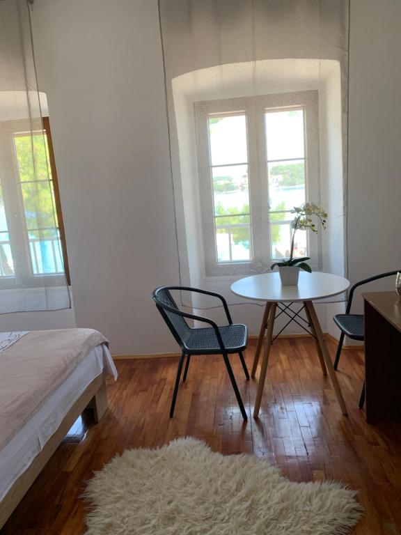 洛维什特Bolero Guest House的客房设有桌椅、桌子和2扇窗户。