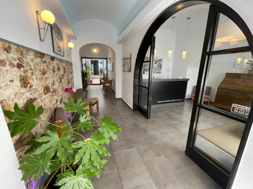 滨海托萨地中海旅馆的走廊上,房间里装有镜子和植物