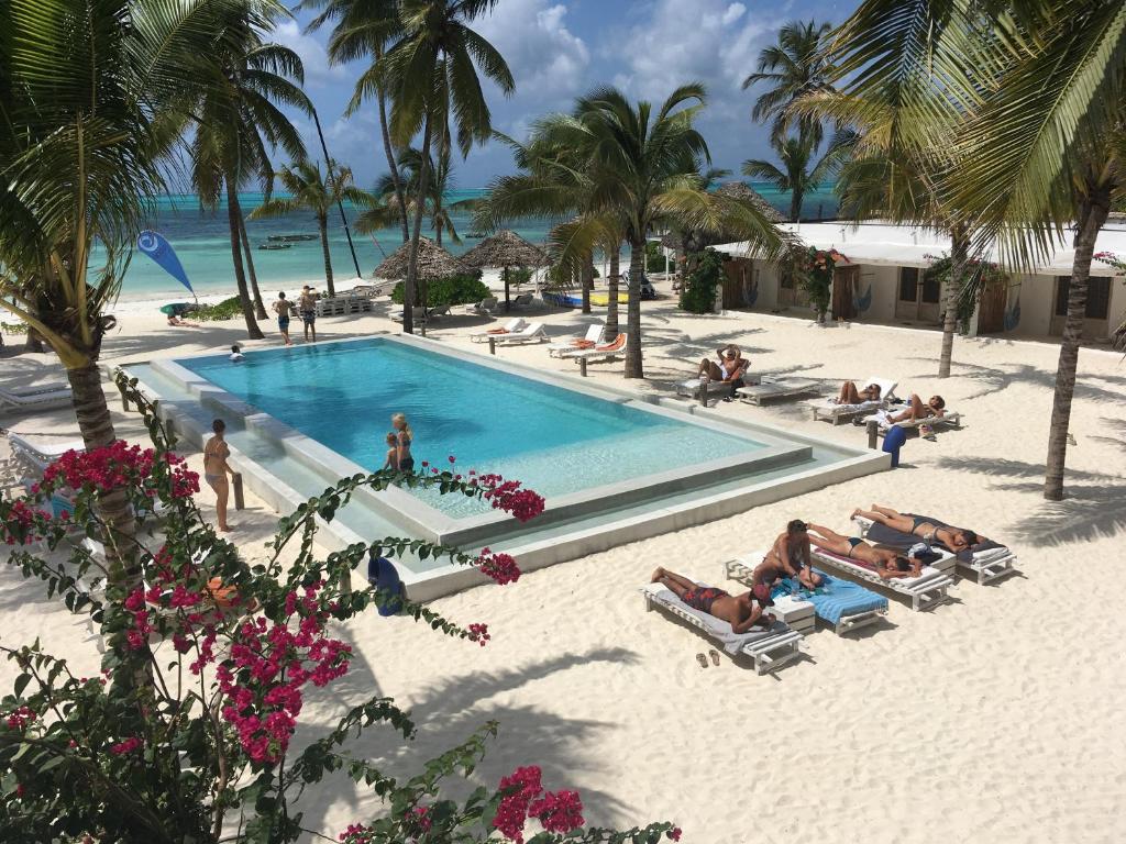 江比阿鲁帕海滩度假酒店的一群人躺在海滩上,靠近一个游泳池