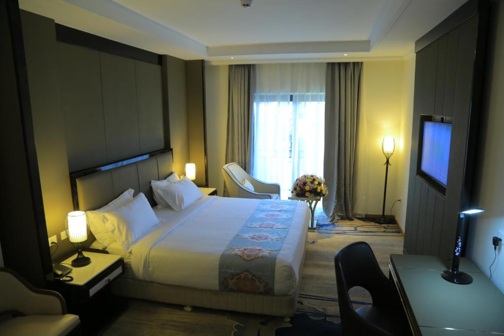 亚的斯亚贝巴Check Inn Hotel Addis Ababa的酒店客房设有一张大床和一台电视。