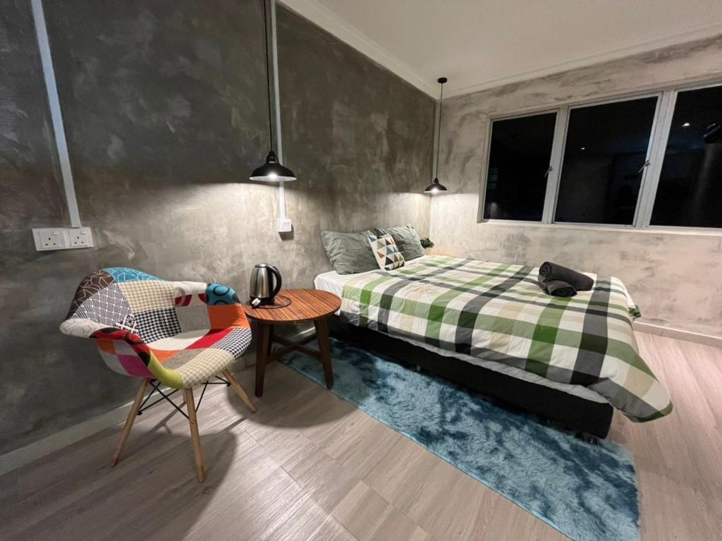 怡保YY Residences的卧室配有1张床、1张桌子和1把椅子