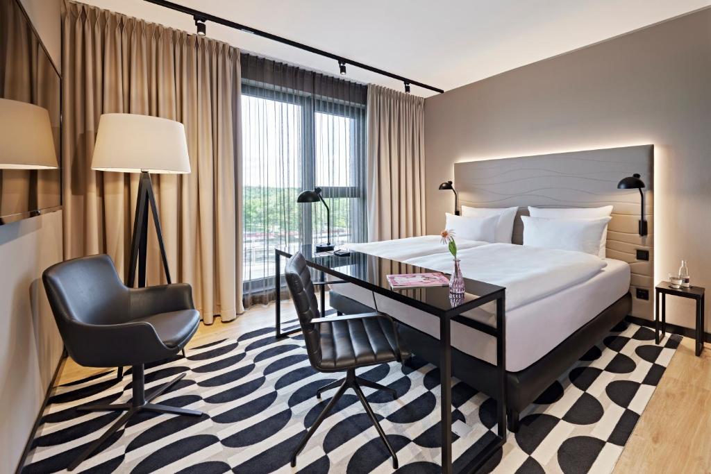 爱尔福特LÉGÈRE HOTEL Erfurt的配有一张床和一张书桌的酒店客房