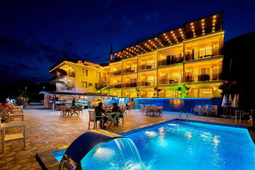 卡斯Kaş Sun Glare Hotel的夜间设有游泳池的酒店