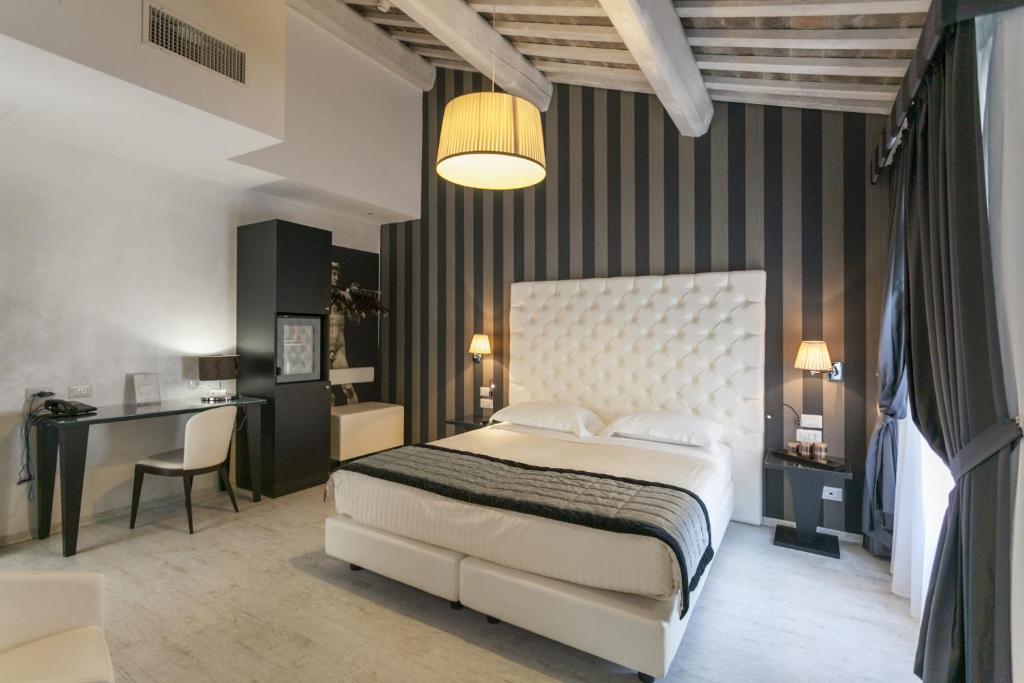 费拉拉那锡那里酒店的卧室配有白色的床、书桌和椅子