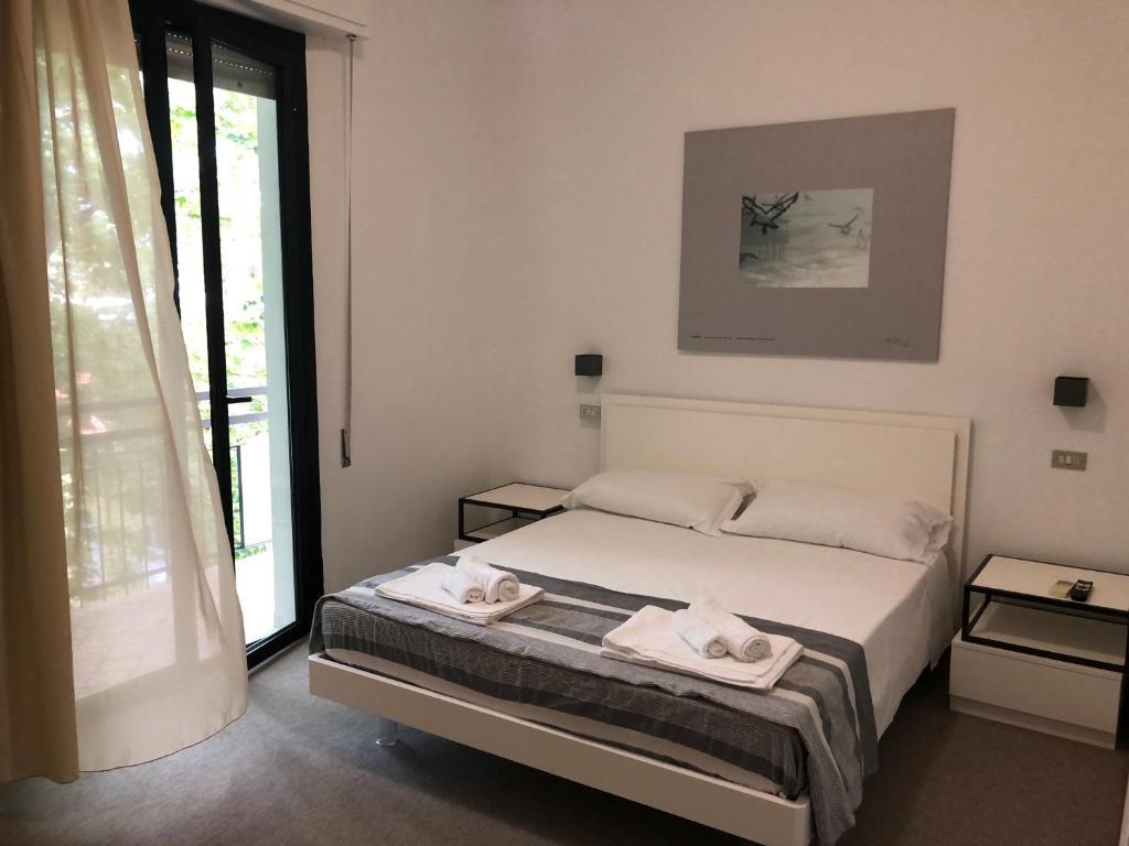 贝拉里亚-伊贾马里纳Vinsea Hotel的一间卧室配有一张床,上面有两条毛巾