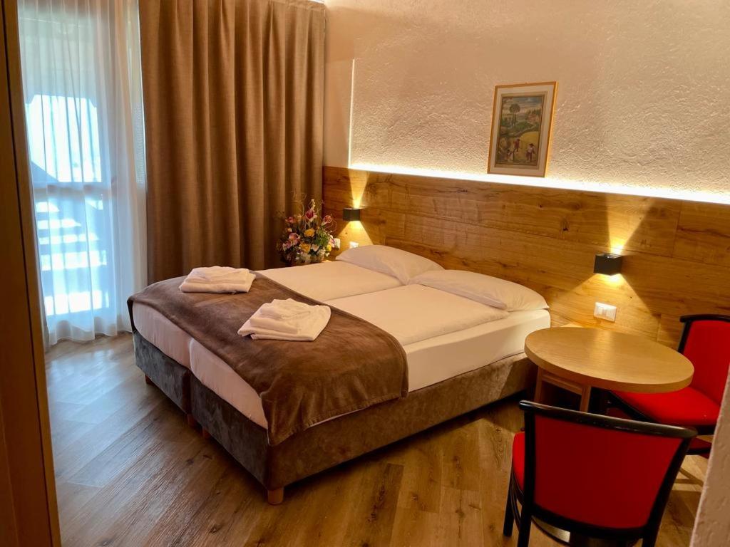 圣洛伦佐因巴纳莱Dependance Soran-H. San Lorenzo的酒店客房带一张床、一张桌子和椅子