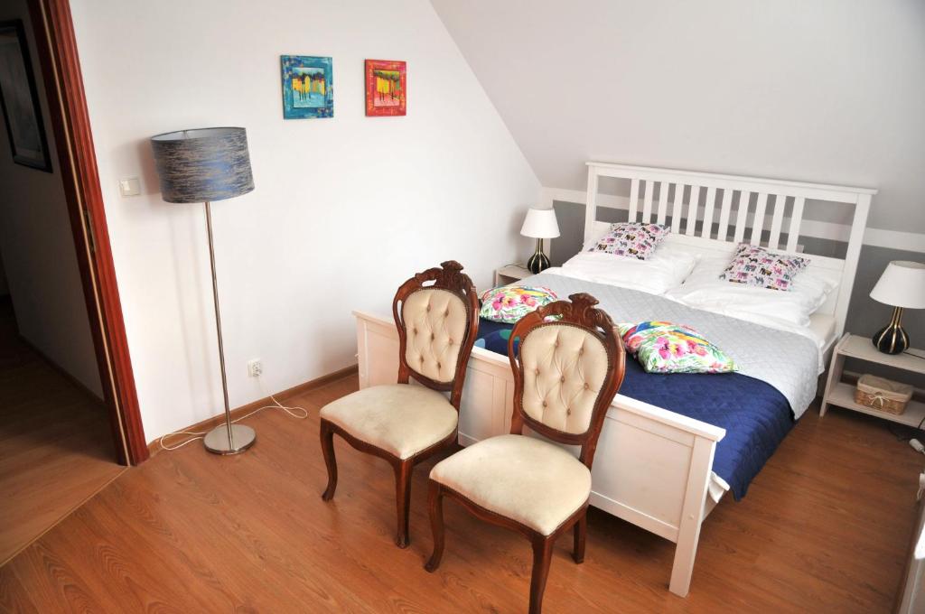 格丁尼亚Apartament pod limbą的一间卧室配有一张床和两把椅子