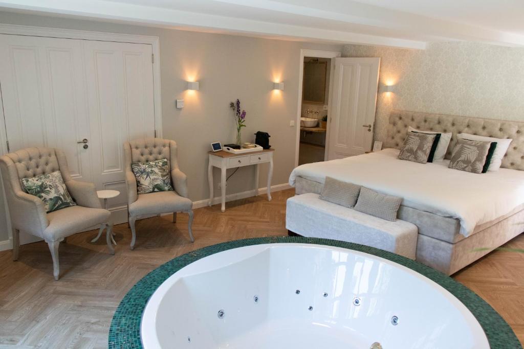 蒂尔堡Guesthouse "Mirabelle" met indoor jacuzzi, sauna & airco的带浴缸和床的酒店客房