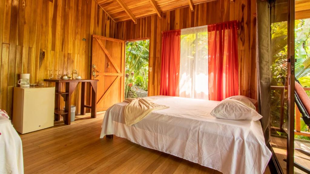 福尔图纳Arenal Rústic Lodge的一间带床的卧室,位于带窗户的房间内