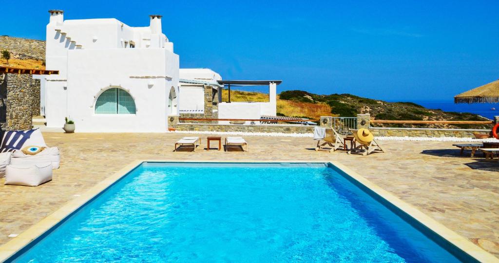 帕罗斯岛Villa Mira Paros - Luxury Suites的白色房子前的蓝色游泳池