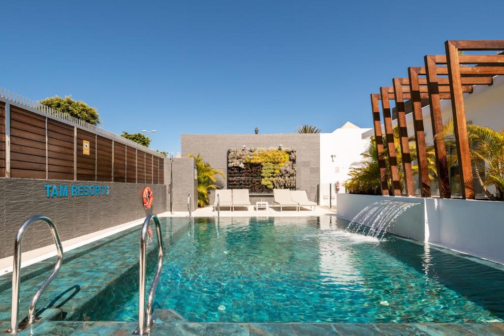 英格兰海滩Silvi Villas by TAM Resorts的房屋内带水景的游泳池