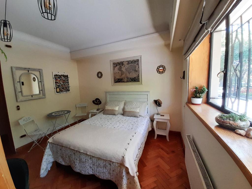 圣地亚哥Bed & Breakfast Lastarria的卧室配有床、桌子和窗户。