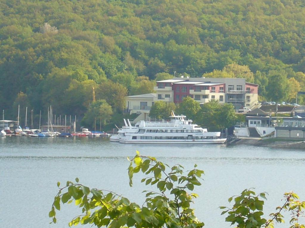 海姆巴赫希尔霍夫酒店的船停靠在水中,靠近一座建筑