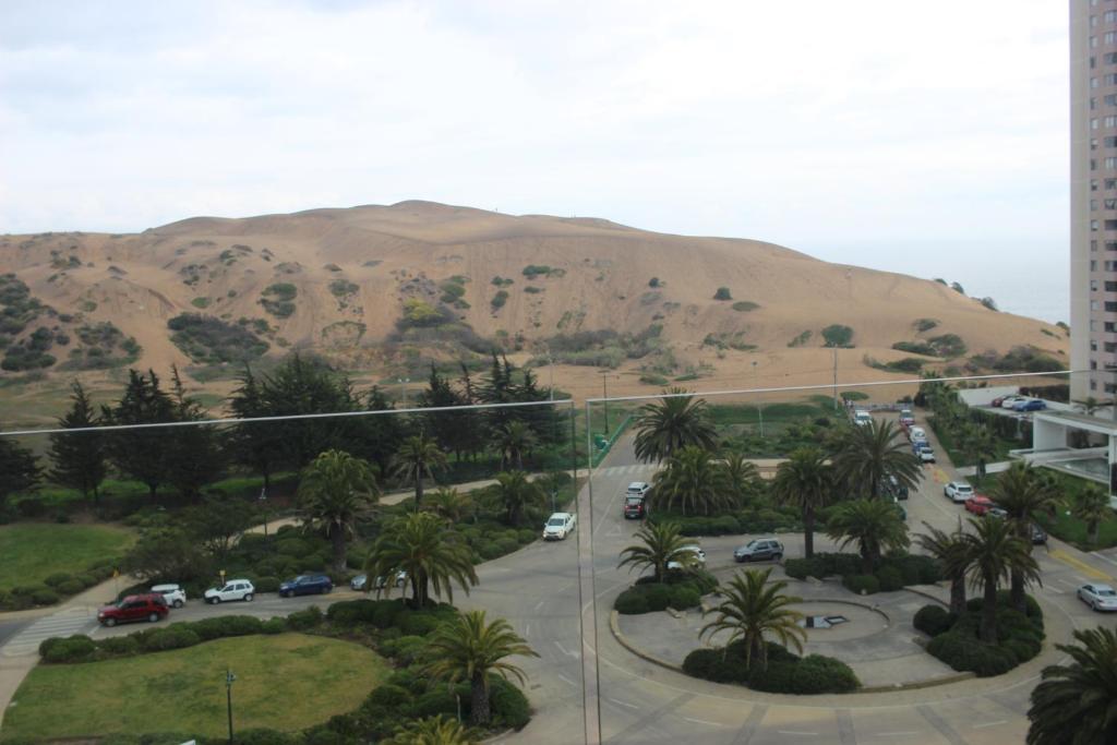 康康Cómodo departamento acceso a dunas de Concón的享有停车场的景色,后面是山脉
