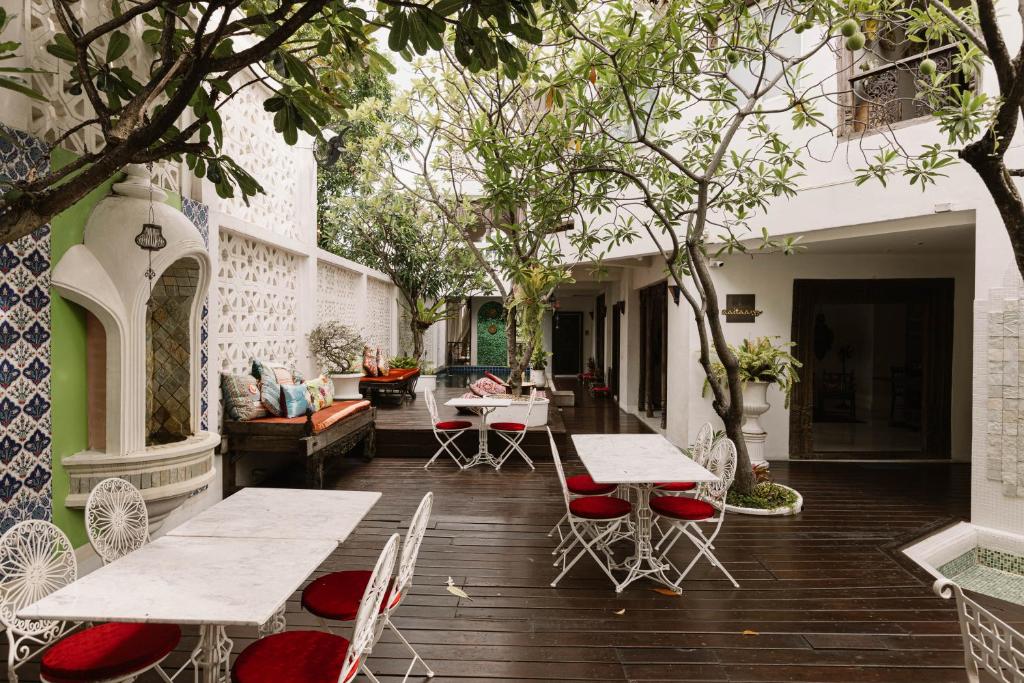 清迈爱宁曼精品酒店的户外庭院配有桌椅和树木。
