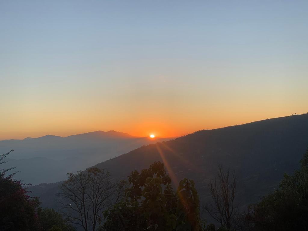纳加阔特Nagarkot Trekkers Inn的山中日落,太阳落在地平线上