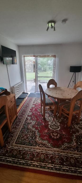 SchnaittenbachFerienwohnung Tom的客厅配有桌椅和地毯。